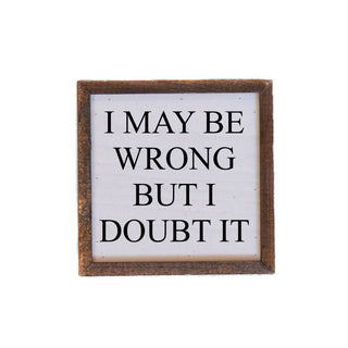 Wooden-framed sign with text 'I MAY BE WRONG BUT I DOUBT IT' on a white background