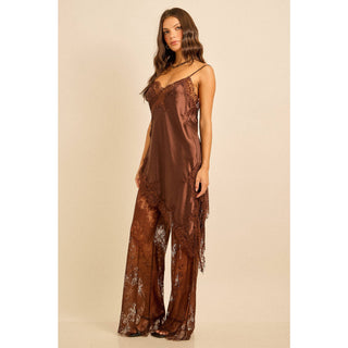Woman wearing a brown satin outfit with lace detail asymmetric top and lace pants