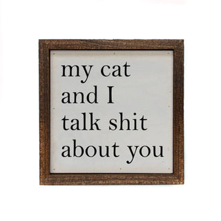 Framed sign with text 'my cat and I talk shit about you' on a white background