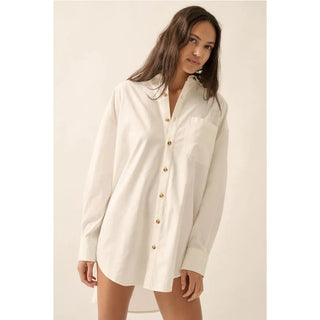 A solid woven mini shirt dress with the following features:
Collared neckline.
Button-front closure.
Chest pocket.
Long sleeves with buttoned cuffs..
Dropped shoulder.
Pleated yoke back.
Curved shirtail hem.
Loose fit.
