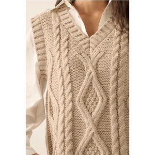 A solid knit sweater vest with the following features:
Cable knit.
V neckline.
Sleeveless.
Ribbed knit neckline, hem, and armholes.
Ribbed knit back.
Loose fit.

