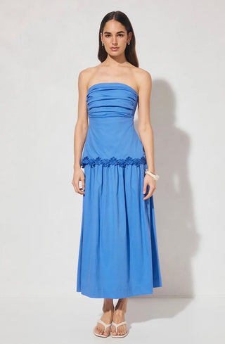 Woman wearing a blue strapless dress with floral details on a white background