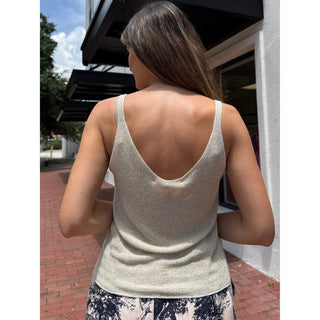Woman wearing a beige tank top outdoors on a sunny day