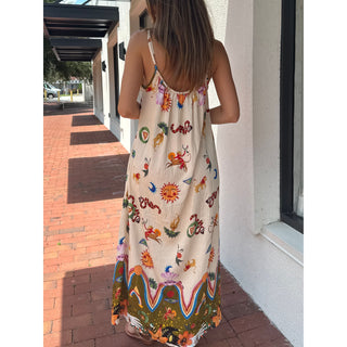 Woman wearing a colorful gypsy style bohemian sundress standing on a sidewalk.
