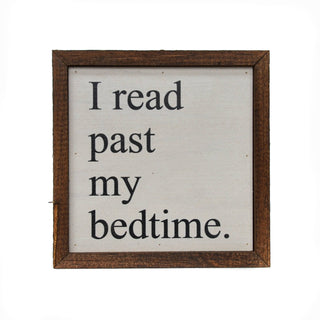 Framed sign with text 'I read past my bedtime' on a white background