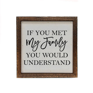 Decorative sign with text 'If you met my family you would understand' in a wooden frame.