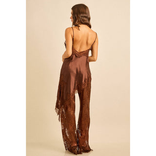 Woman wearing a brown satin outfit with lace detail asymmetric top and lace pants