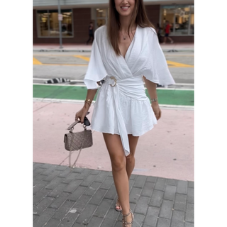 white romper with flowy sleeves and gold buckle